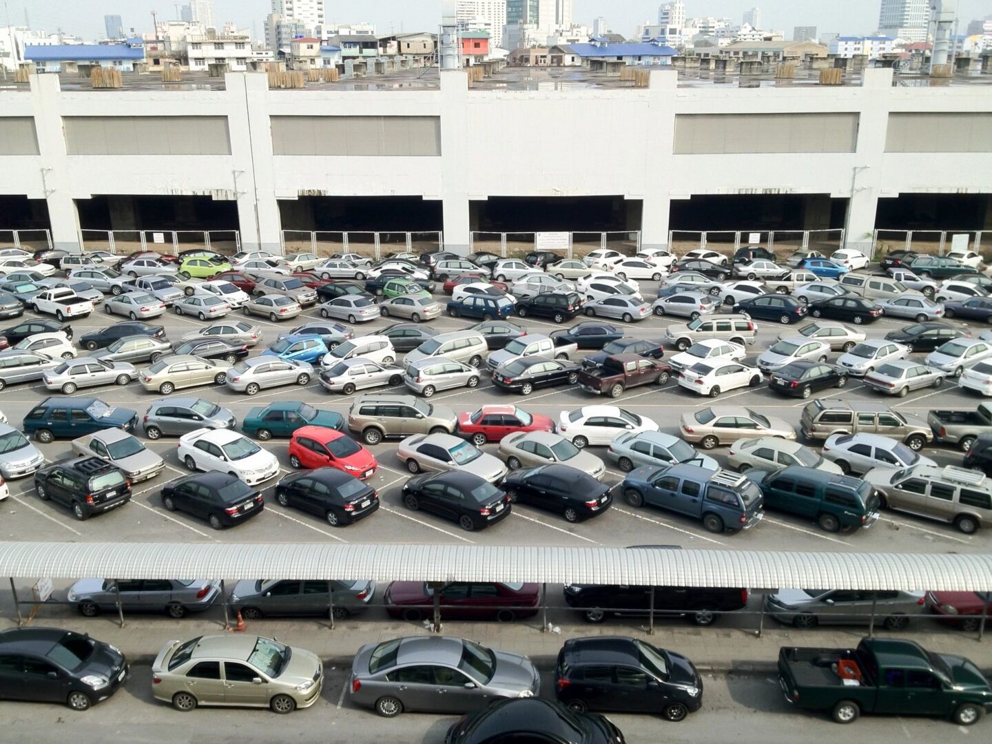 A parking lot filled with lots of cars parked.