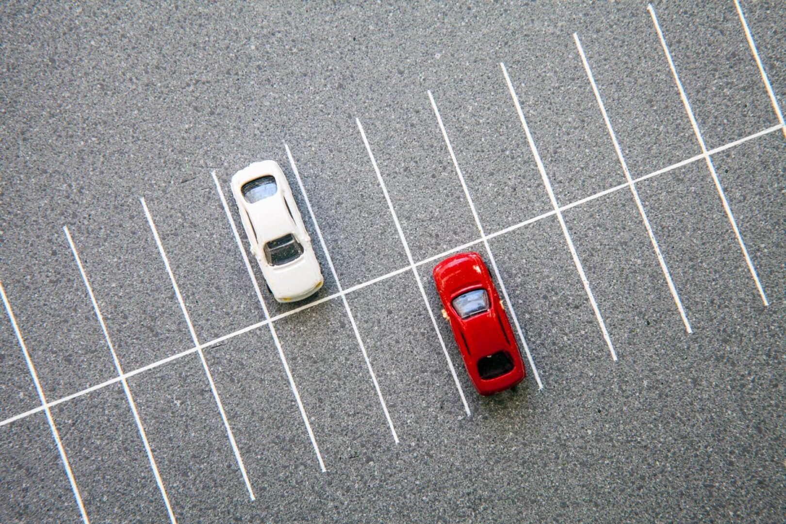 Two cars are parked in a parking lot.