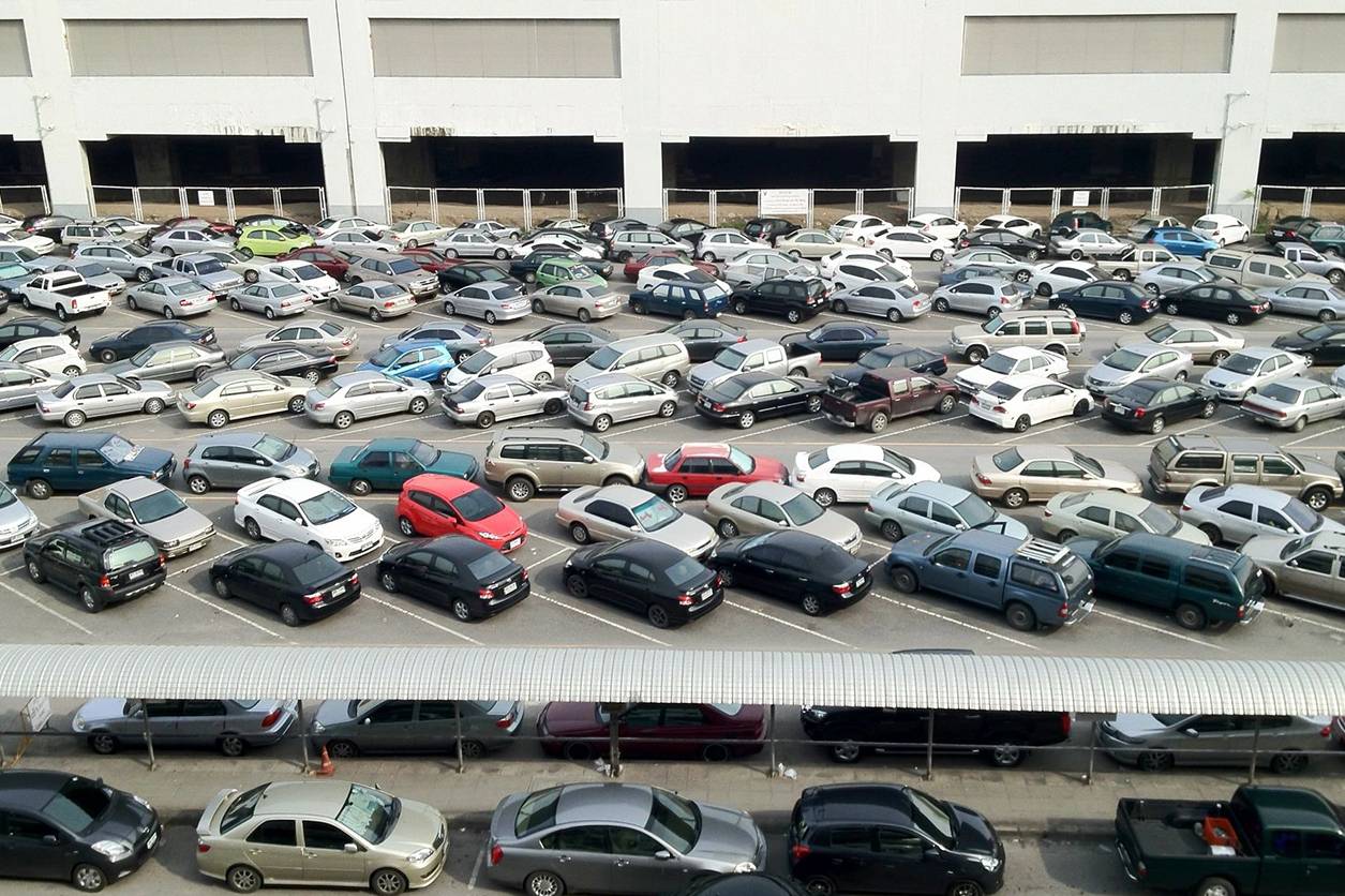 A parking lot filled with lots of cars parked in it.